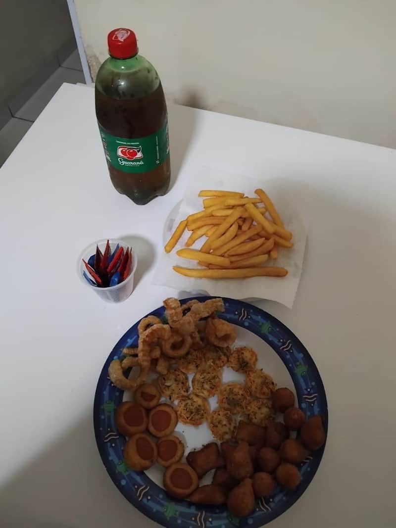 Mesa montada com porções e guaraná
